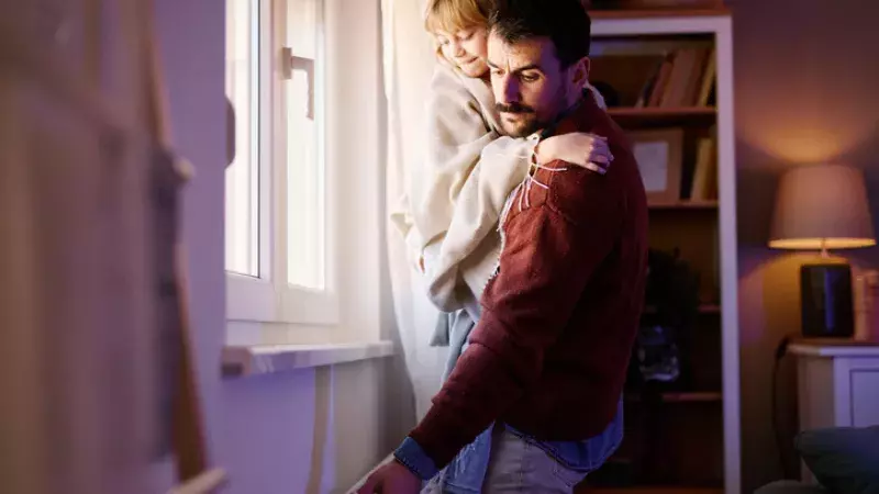 Un père tenant sa fille dans ses bras vérifie le chauffage 